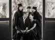 Graduates in graduation gowns and throwing their mortarboards in a photography studio setting during a family photoshoot in Singapore, White Room Studio. Credit: White Room Studio Pte Ltd