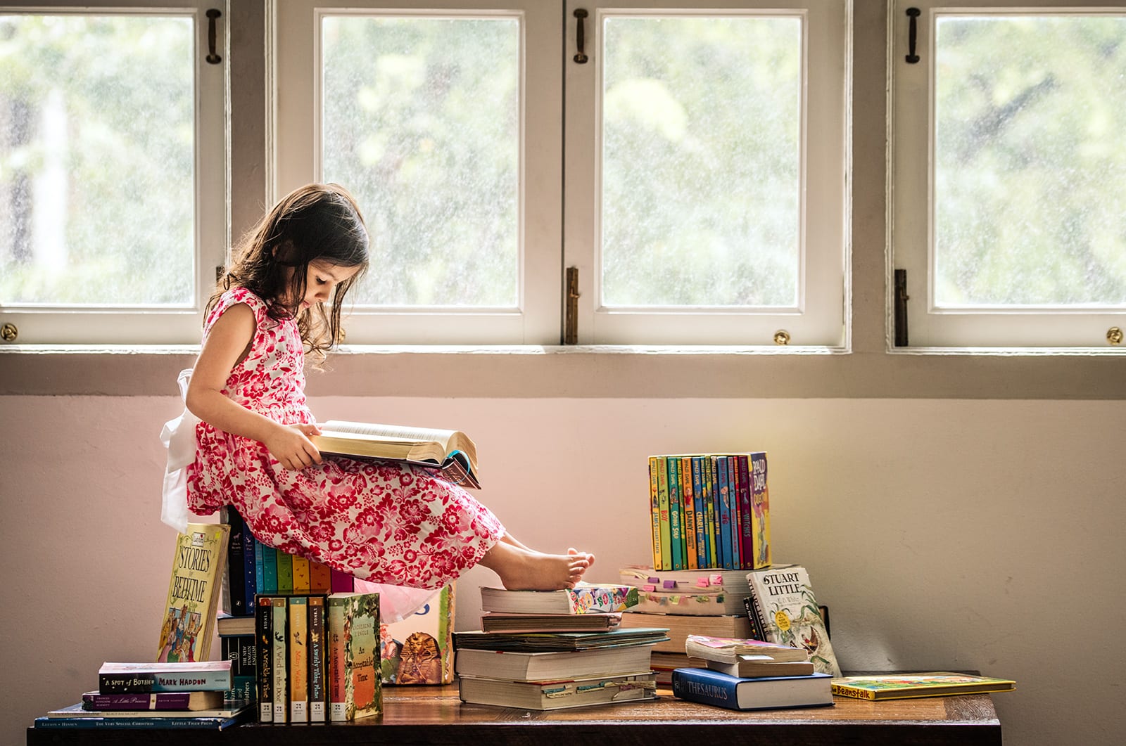 Children-Photography-Natural-young-girl-reading-books Children Photography Natural lighting large window young girl sitting on and reading books